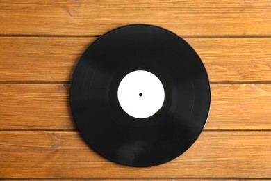 Vintage vinyl record on wooden table, top view