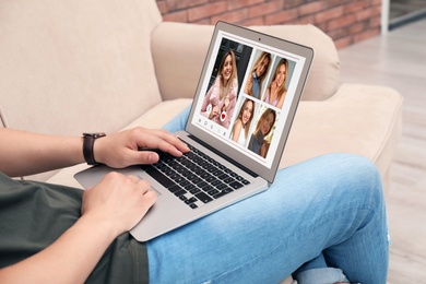 Man visiting dating site via laptop indoors, closeup