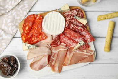 Photo of Tasty ham with other delicacies served on white wooden table, flat lay