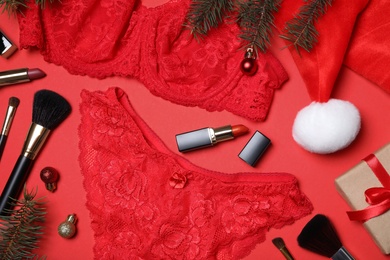 Christmas gift set with sexy women lingerie on red background, flat lay