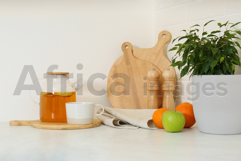 Photo of Different kitchen items and houseplant on countertop indoors