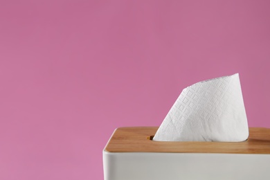 Holder with paper tissues on pink background, closeup. Space for text