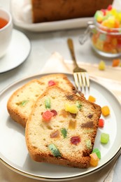 Delicious cake with candied fruits on plate, closeup