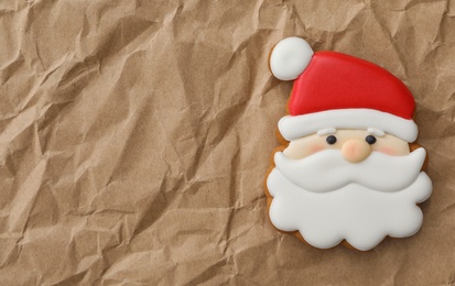 Christmas Santa Claus shaped gingerbread cookie on crumpled parchment, top view. Space for text
