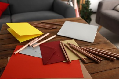 Photo of Envelopes and stationery for making greeting cards on wooden table indoors