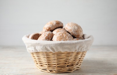 Tasty homemade gingerbread cookies in basket on white wooden table