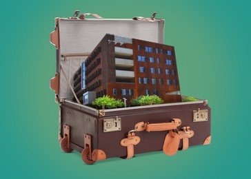 Building in retro suitcase on green background