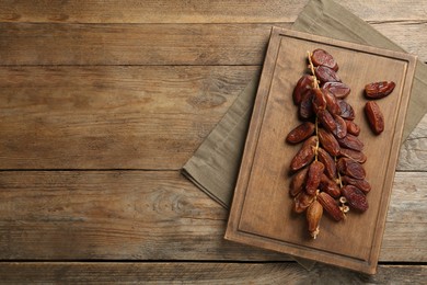 Sweet dried dates on wooden table, top view. Space for text
