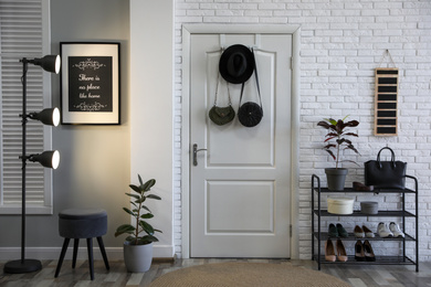 Hallway interior with stylish furniture, shoes and plants