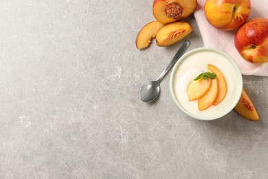 Delicious yogurt with fresh peach and mint on grey table, flat lay. Space for text