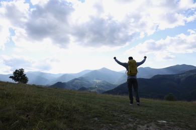 Triumphant tourist on top of mountain, back view. Space for text