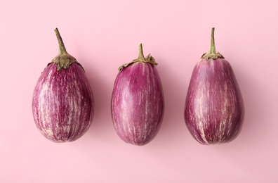 Raw ripe eggplants on pink background, flat lay