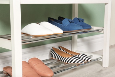 Photo of Modern rack with different female shoes indoors