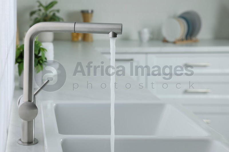 Photo of Stream of water flowing from tap in kitchen, space for text