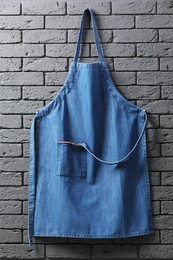 Clean denim apron on grey brick wall