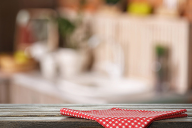 Red towel on wooden table in kitchen. Space for text