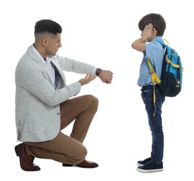Teacher pointing on wrist watch while scolding pupil for being late against white background