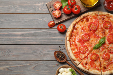 Photo of Delicious pizza Margherita and ingredients on wooden table, flat lay. Space for text