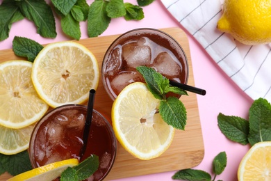 Delicious iced tea with lemon and mint on pink background, flat lay