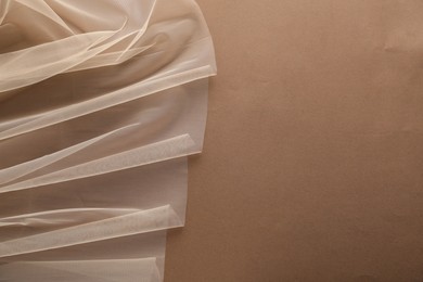 Photo of Beautiful tulle fabric on brown background, top view. Space for text