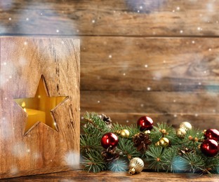 Image of Christmas lantern with burning candle and festive decor on wooden table 