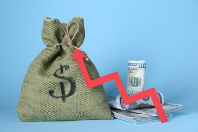 Economic profit. Money bag, banknotes and arrow on light blue background