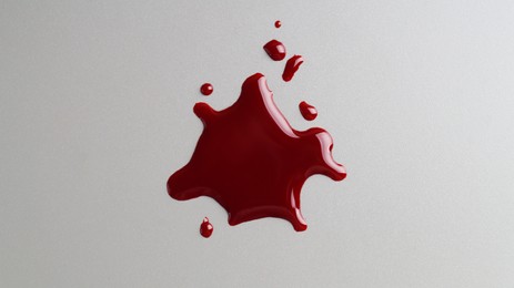 Stain and drops of blood on grey background, top view
