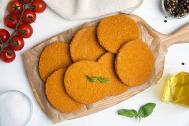 Delicious fried breaded cutlets served on white table, flat lay