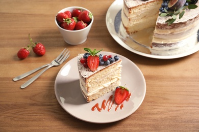 Piece of delicious homemade cake with fresh berries served on wooden table