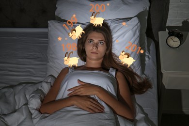 Image of Young woman trying to fall asleep counting sheep in bed at night, above view