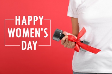 Closeup view of woman with dumbbell as girl power symbol on red background. Happy Women's Day