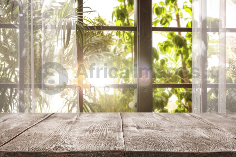 Empty wooden table in front of window. Sunny morning 