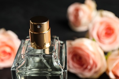 Bottle of perfume on blurred background, closeup. Space for text