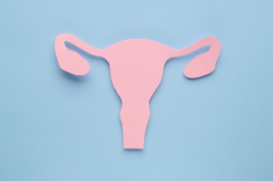 Photo of Woman`s health. Paper uterus on light blue background, top view