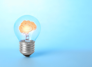 Lamp bulb with human brain inside on blue background, space for text. Idea generation