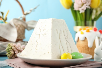 Traditional cottage cheese Easter paskha on light blue table, closeup