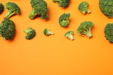 Fresh tasty broccoli on orange background, flat lay. Space for text