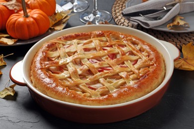 Delicious homemade apple pie and autumn decor on black table. Thanksgiving Day celebration