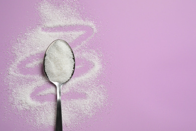 Photo of Granulated sugar and spoon on lilac background, flat lay. Space for text