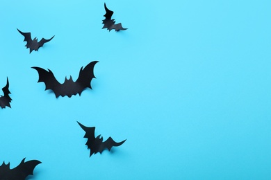 Paper bats on light blue background, flat lay with space for text. Halloween decor