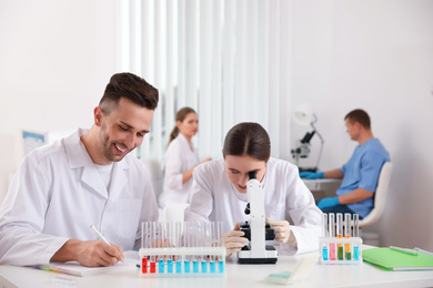 Medical students with microscope in modern laboratory