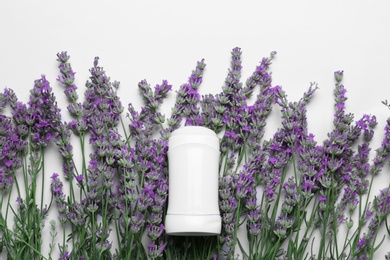 Female deodorant and lavender flowers on white background, top view