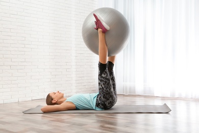 Photo of Young woman doing fitness exercises at home
