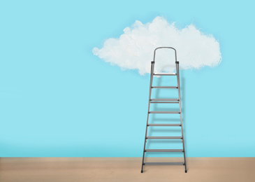 Metal stepladder near light blue wall with painted cloud. Conceptual design 
