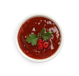 Spicy chili sauce with parsley on white background, top view