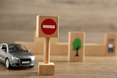Traffic sign No entry and toy car on wooden table. Passing driving license exam
