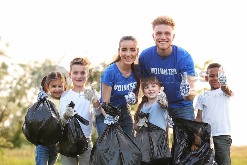 Volunteers and kids with bags of trash in park