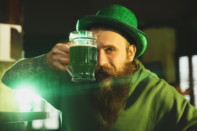Man with glass of green beer in pub. St. Patrick's Day celebration