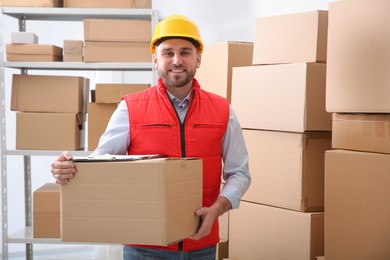 Young man with cardboard box at warehouse
