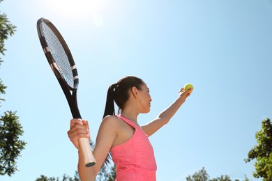 Woman playing tennis outdoors, low angle view